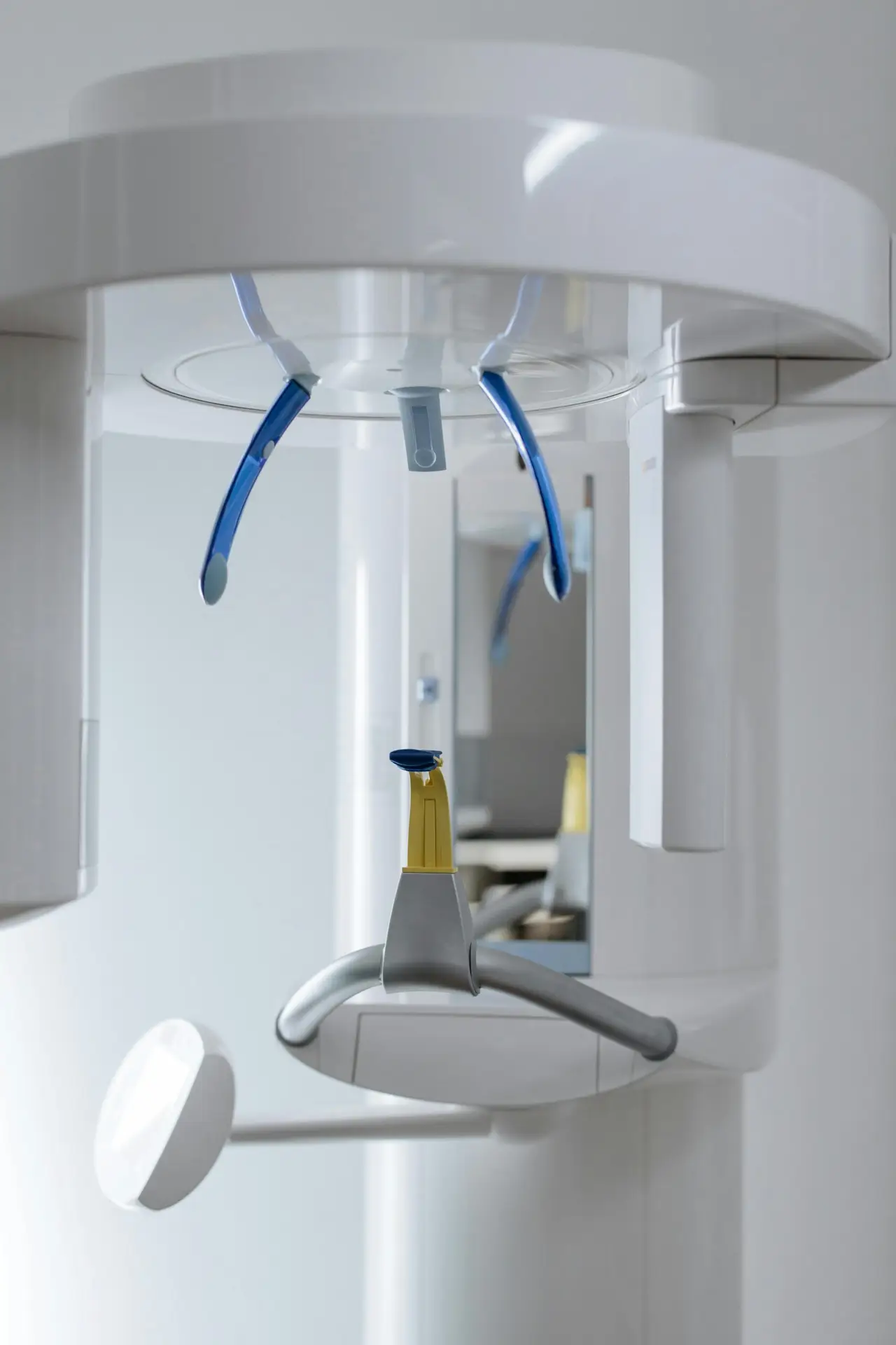 Xray machine that is white with a yellow bite and blue head demobilizer.